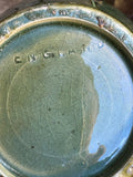 Close-up of the impressed ENGLAND mark on the crazed green-glazed base of an early 20th century art pottery vase