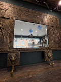 Brass coat rack showing tavern scene panel and pair of lion-head hooks