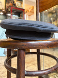 Rear view of an RAF airman's peaked cap in blue-grey wool with a black woven band