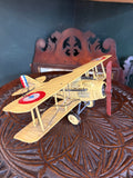 Vintage yellow metal Nieuport 17 WWI biplane model with French roundels, side view