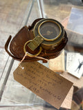 Verner’s Pattern compass sitting on top of original leather case, inside display cabinet 