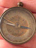 Close-up of compass dial showing cardinal points and degree scale, held in hand
