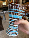 Hand holding West German pottery vase showing hourglass shape