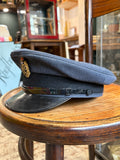 Side view of an RAF airman's peaked cap showing the black band, patent peak and chinstrap with side button