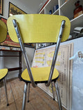 Close-up of chair back from behind, showing chrome crisscross support and screw fixings.