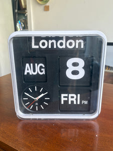 Vintage Habitat flip clock with London display, showing date, day, and analogue clock face on wooden surface. 
