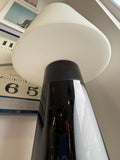 Low angle upward view of Habitat Joséphine lamp showing underside of white glass shade and top of tapered black glass base with white oval panel detail​​​​​​​​​​​​​​​​