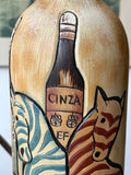 Close-up of ceramic bottle showing relief-moulded bottle of Cinza flanked by two stylised zebras.