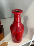 Close-up of red ceramic vase neck and rim showing glossy mottled glaze