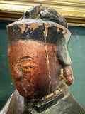 Close-up of age crack through face of antique Chinese carved wood figure