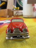 Front view of post-war US-Zone Germany red tin litho sedan toy car showing chrome-effect grille and headlights
