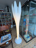 White Bonaldo Eos floor lamp illuminated among vintage pottery and toys