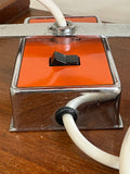 Close-up of orange enamel and chrome square base of 1970s space age eyeball lamp showing toggle switch