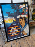 Full view of framed original 1984 Soviet Navy propaganda poster showing young sailor in white naval cap and striped vest before warship superstructure, with bold Cyrillic text reading Boevym Traditsiyam Verny