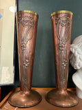 Pair of Art Nouveau copper and brass vases with poppy repoussé design standing side by side