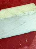 Macro view of bone domino tile edge showing natural material texture