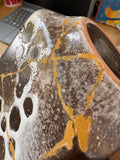 Close-up detail of gold repair line and crater glaze texture