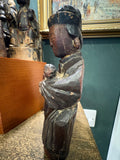 Profile of antique Chinese Guanyin figure showing swaddled child in arms