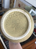 Close-up of a ceramic vase's base with a view of the form and size number 1809/25