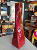 West German Fat Lava twisted ceramic vase in red and orange glaze, displayed on a table in a shop interior.