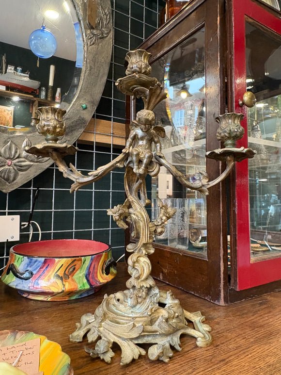 Ornate antique three-armed brass candelabra with cherub figure and floral decoration, Rococo style. 