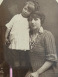 Close-up of Edwardian postcard showing mother in dress with child. 