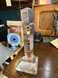 Vintage plexiglass lighthouse souvenir on shelf with other objects