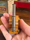Miniature cannon shown in hand for scale reference