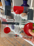 Hand holding a vintage Martini apero tray showing the frosted glass texture and red accents