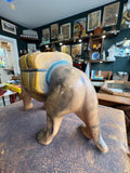 Rear view of the vintage ceramic tiger planter showing the plain matte grey-brown glazed body, the mustard yellow saddle planter with teal blue strap visible from behind, and the four sturdy legs.