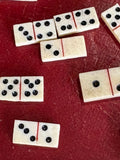 Group of miniature bone domino tiles showing varied pip counts