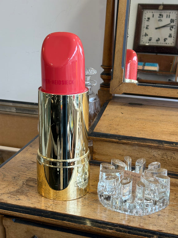 Piper-Heidsieck red and gold lipstick-shaped champagne cooler on vintage dressing table