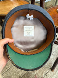 Interior of an RAF airman's cap showing the tan sweatband, grey lining, issue label and green peak underside