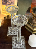 Matching pair of antique glass candlesticks on display