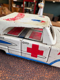 Close-up of passenger side door detail on vintage Japanese tinplate ambulance showing red cross and window litho