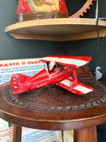 Side view of red and cream metal Pitts Special biplane model G-PITZ showing wire bracing