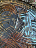 Close-up of chased lines and punched matted ground on a Celtic knot brass dish