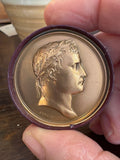 Held bronze medallion showing Napoleon I in laurel wreath, signed Andrieu.F