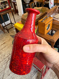 	Hand holding Manfred Buchholz red glazed vase, side angle