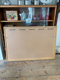 Reverse of the framed poster showing a Corri-Cor backing board in a natural wood frame, with a hanging wire attached. Clean MDF-style backing typical of professional framing.
