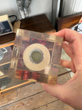 Base of Giraudon resin block showing circular bulb fitting and screw thread encased in scratched clear resin.