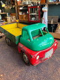 Three-quarter front view of vintage 1950s Wells-Brimtoy red and green tinplate clockwork flatbed truck