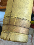 Close-up of olive painted body of Soviet Cold War artillery shell display piece showing aged surface texture and wear