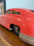 Close-up side detail of vintage Gescha Porsche 356 tin toy car showing rubber tyre and body wear