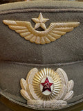 Close-up of a Soviet Air Force winged star badge above an officer's cockade with red enamel hammer and sickle