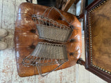 Two wine baskets laid on their sides on a leather chair seat, showing woven bodies