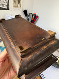 Underside of a Crawford's biscuit tin showing four bracket feet and wear to the bronze finish on the moulding
