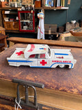 Side profile of vintage 1960s Japanese tinplate ambulance toy car showing red cross and blue stripe livery