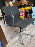 Eames EA108 chair, three-quarter front view, showing armrest, seat, and five-star swivel base.
