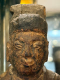Close-up of serene carved face and tall hat on antique Chinese wood figure
